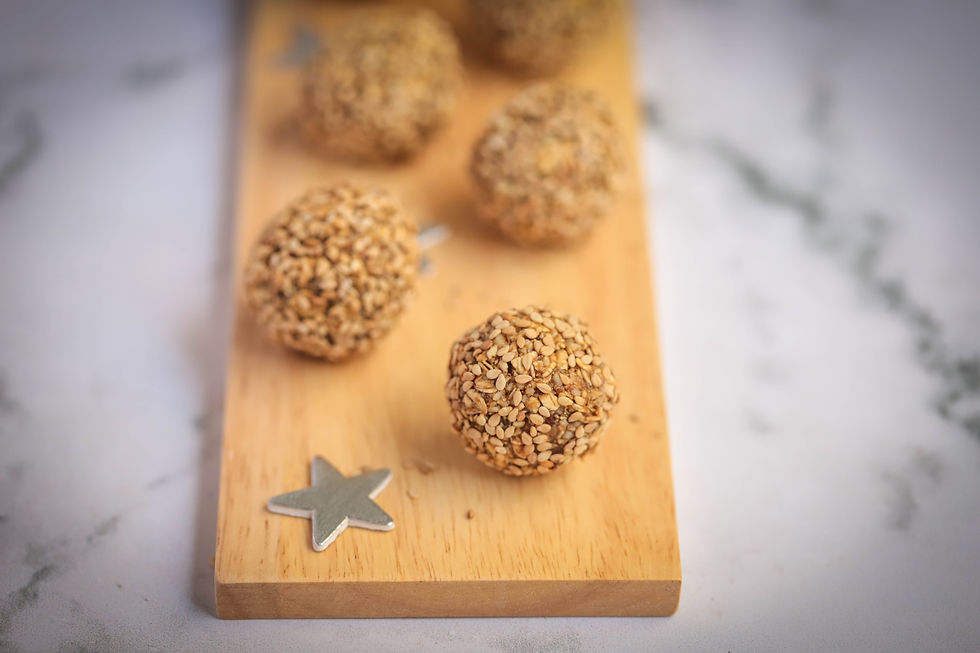 Close-up view of ginger energy balls stacked on a wooden table