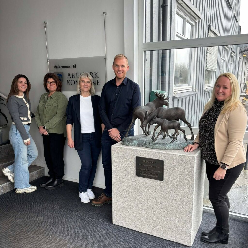 Daglig leder ved Arkiv Øst avbildet inne på kommunehuset i Aremark, sammen med tre kvinner og en mann. Personene står oppstilt på rad og smiler. 