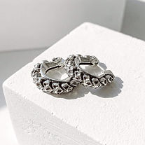 Ophidian Huggie Earrings on a plaster plinth