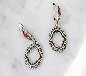 venus bare earrings with orange sapphires on marble surface