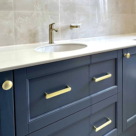 Blue and gold bathroom design with niche in walk in shower.