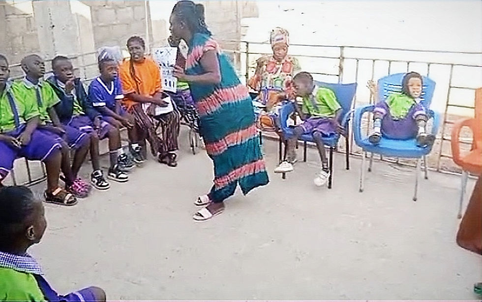 High angle view of a volunteer teaching a child with disabilities outdoors in northern Ghana