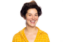 Woman smiling on white background wearing yellow top