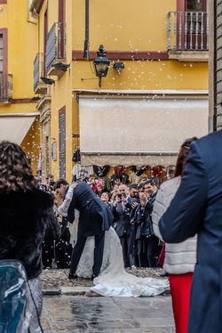 Married couple kissing in front of guests