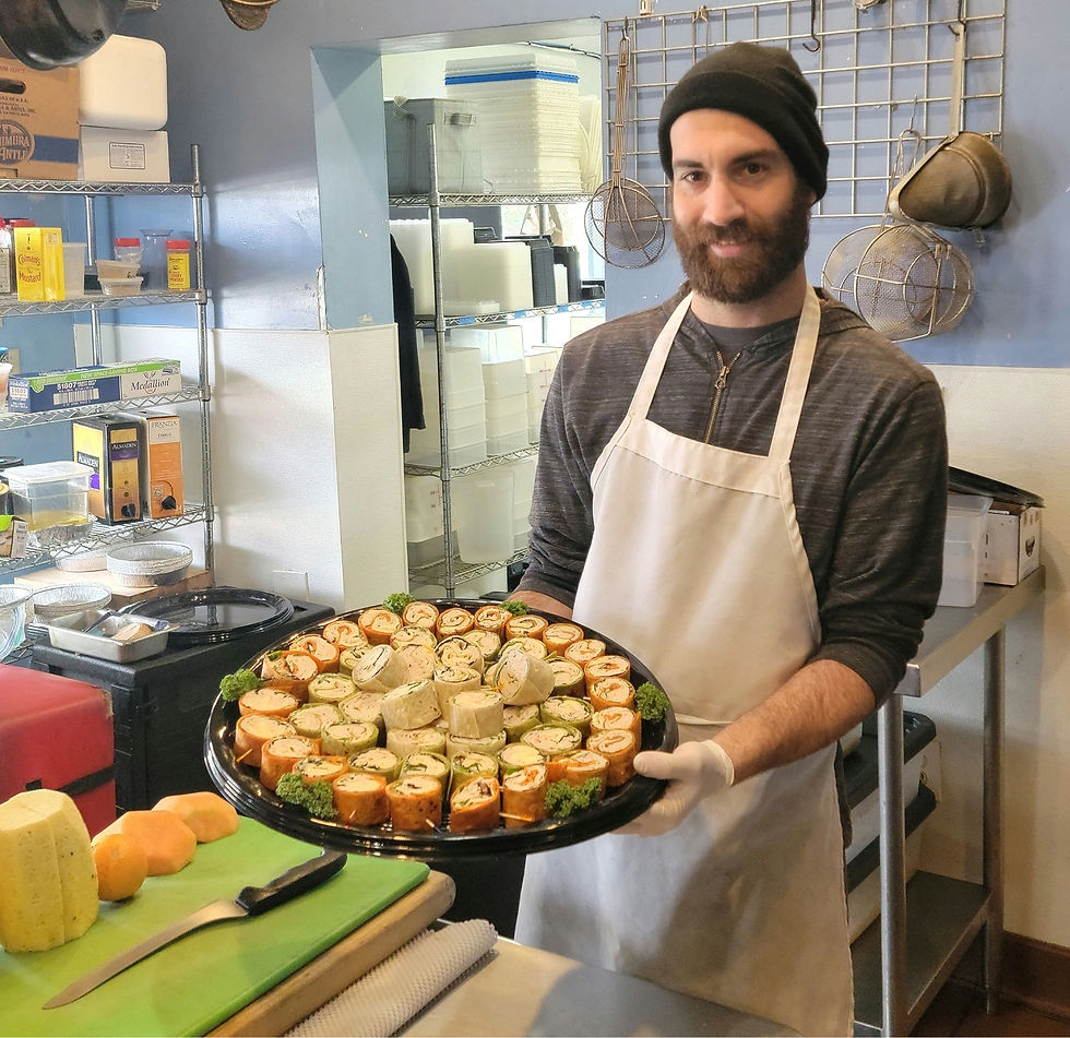 Smiling chef presents catering platter of appetizers