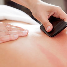 Large bone scraper tool being used ruing a guasha acupuncture treatment.jpg