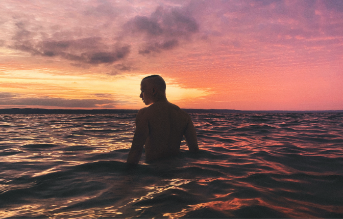 Sexy man standing on shore beach shallow water body positivity sunset