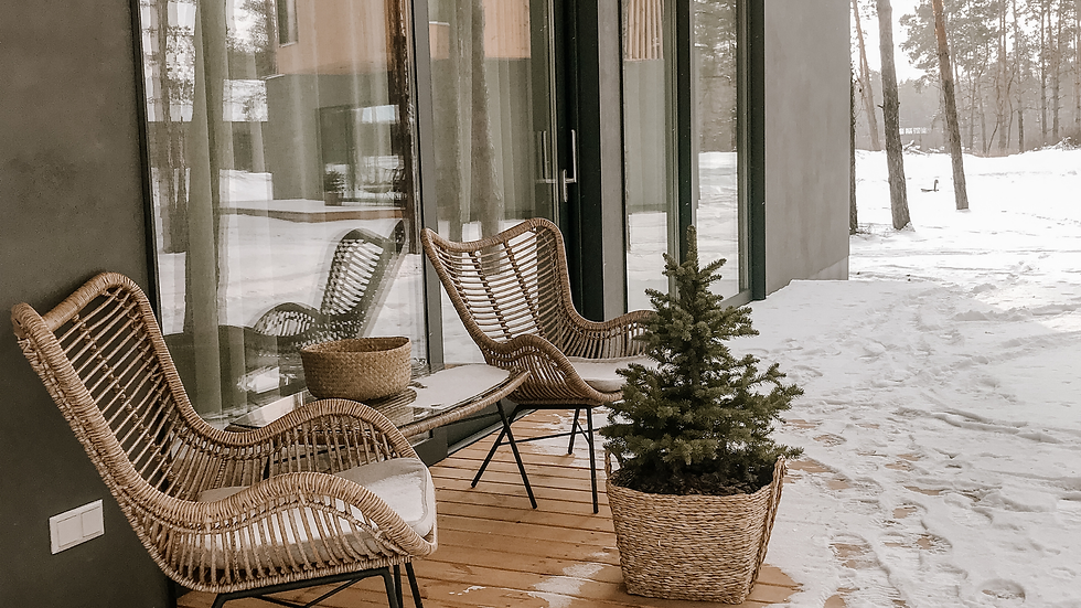 deck in winter time with two chairs and a small festive tree, with snow tracks all over