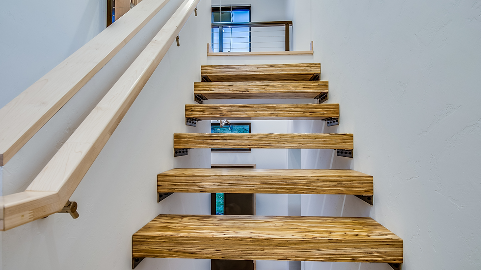closeup of floating wood stairs and sleek square handrail