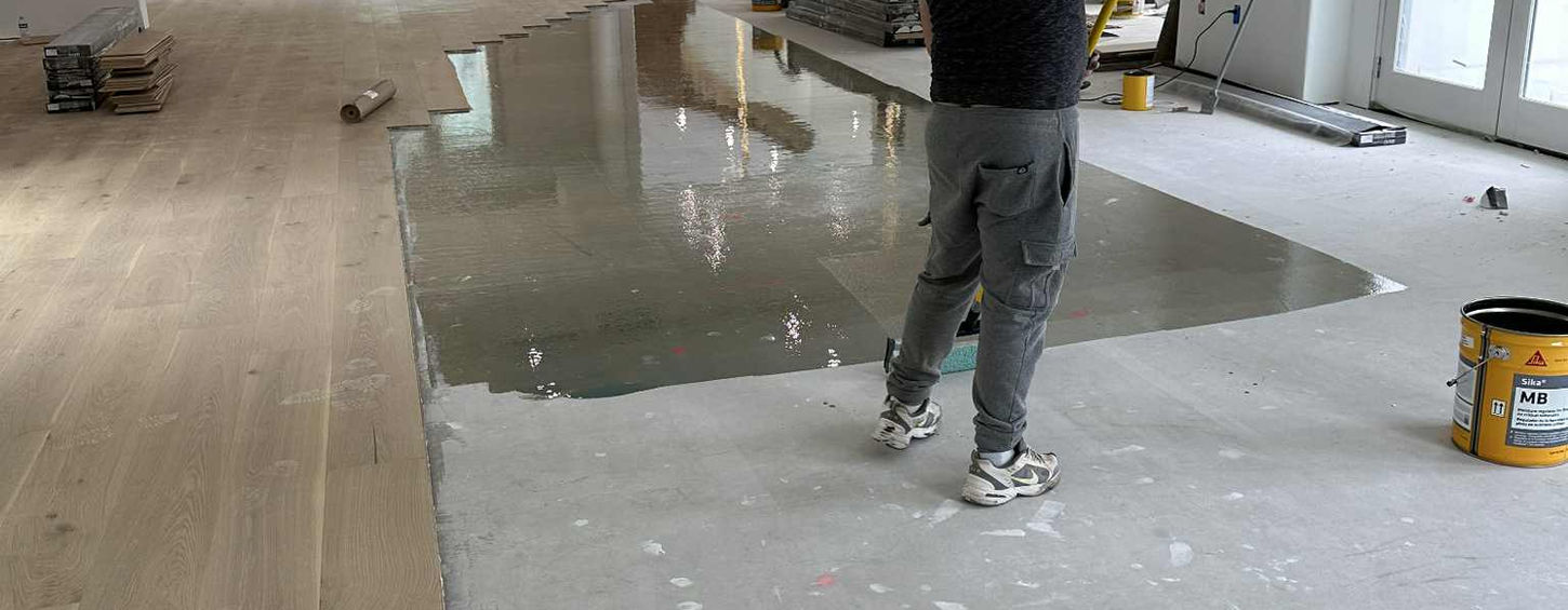 Gio Wood Floors technician applying moisture barrier to concrete subfloor for durability