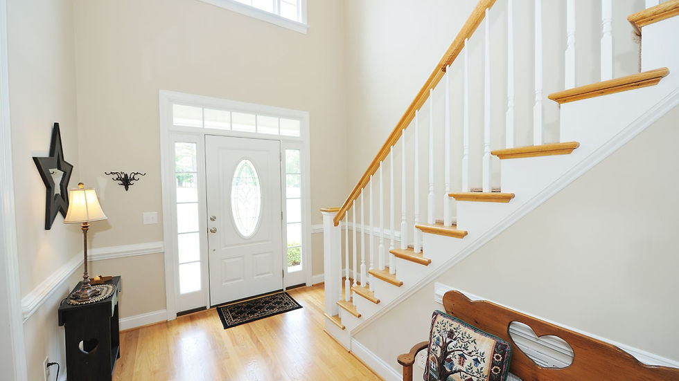 inside home entryway with staircase to the right the treads matching the wood floors