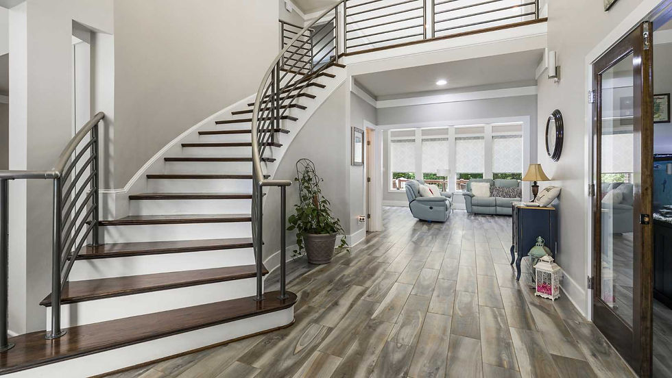 an indoor railing made out of stainless steel framing the photo and the hallway and living room in the backdrop