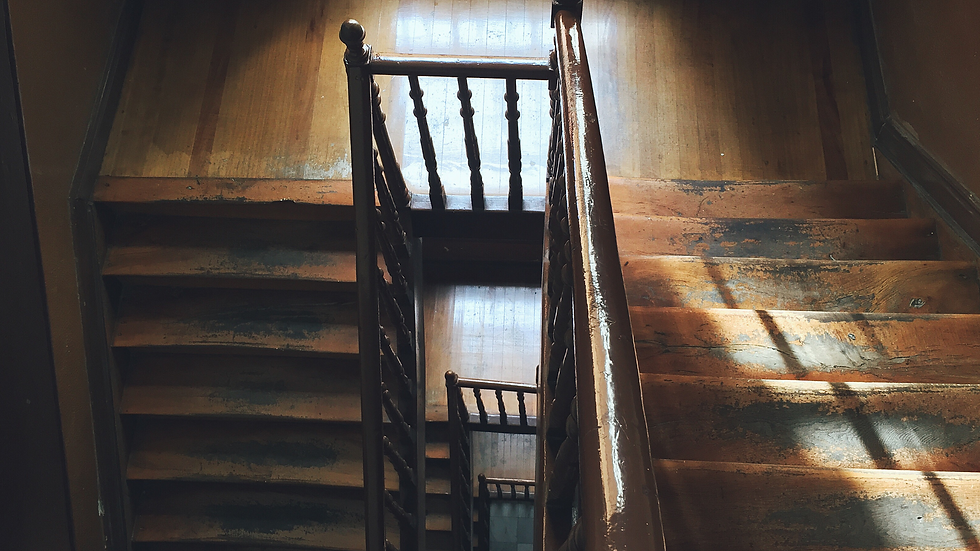 looking down at an old wooden staircase stained in a dark color