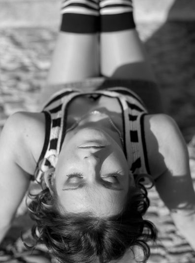 Femme allongée, jambes levées, en noir et blanc