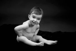 Bébé souriant assis en noir et blanc