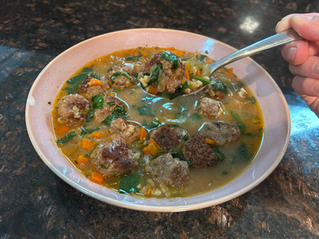 Italian wedding meatball soup; close up shot of spoon in soup