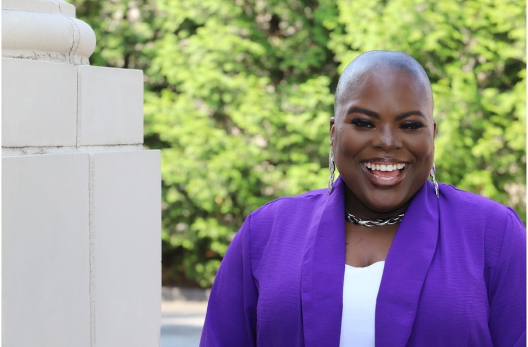 Brittney Sherell smiling in a purple blazer