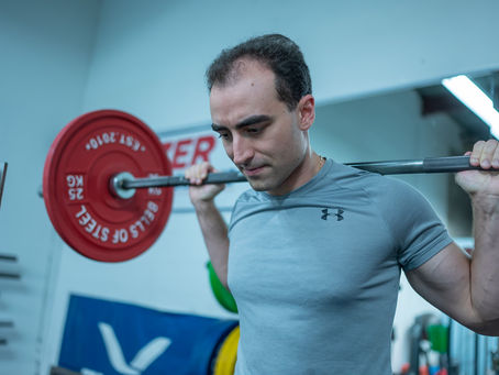 Coach Stephen getting ready to squat with a barbell on his back