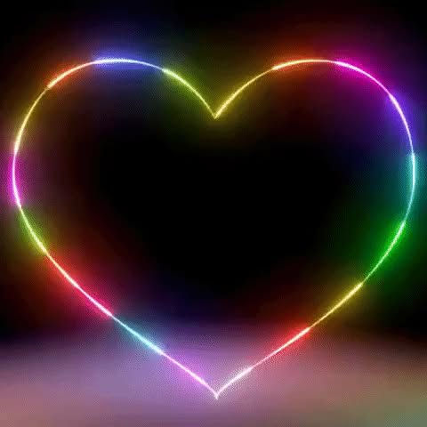 Neon heart with rainbow colors on a dark background, creating a glowing effect. The scene conveys a vibrant, uplifting mood.