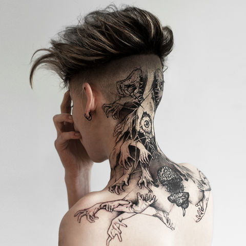 Tattoo showing an anatomical eye, a sliced brain, and dozens of interlaced hands wrapping around the neck and upper back in a surreal composition. Tattoo by Delphine Cencig, French artist