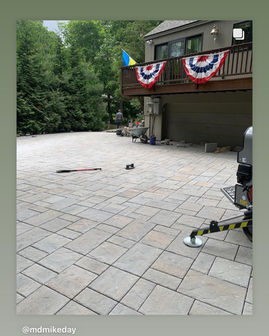 Patio with pavers and a house, with patriotic bunting in background.
