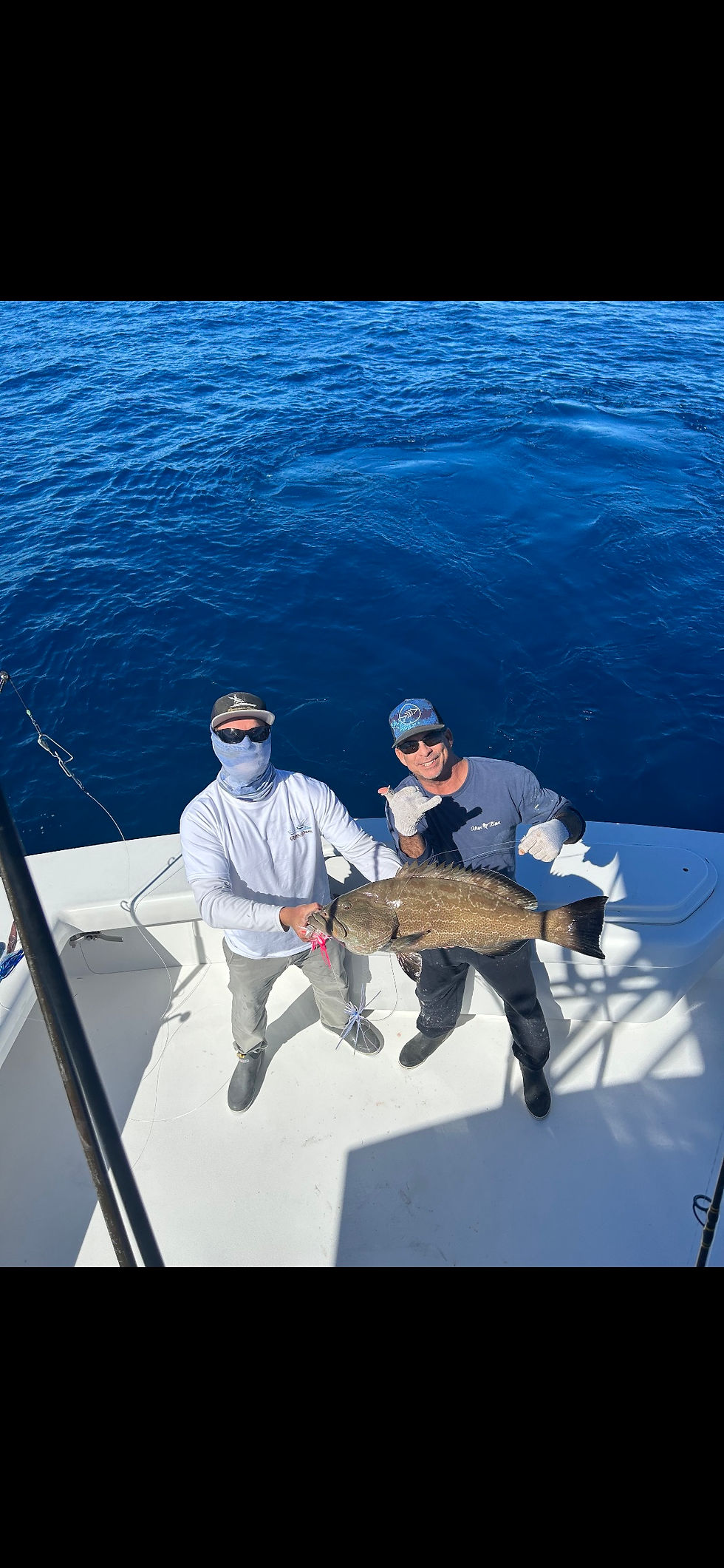 charter guests holding black grouper