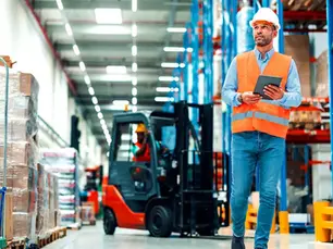 EHS engineer inspecting workplace pedestrian detection technology in a warehouse