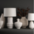 An assortment of white ceramic vases and lamps that have antique decor elements.