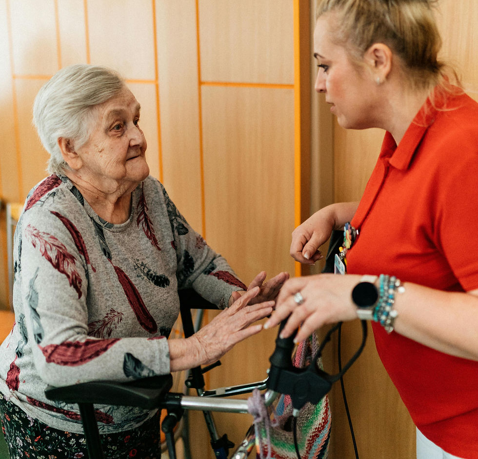 A compassionate caregiver talking with a senior woman using a walker in a Vancouver senior living facility.
