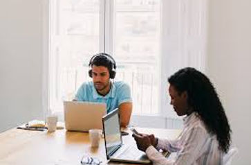 two people co-working on laptops