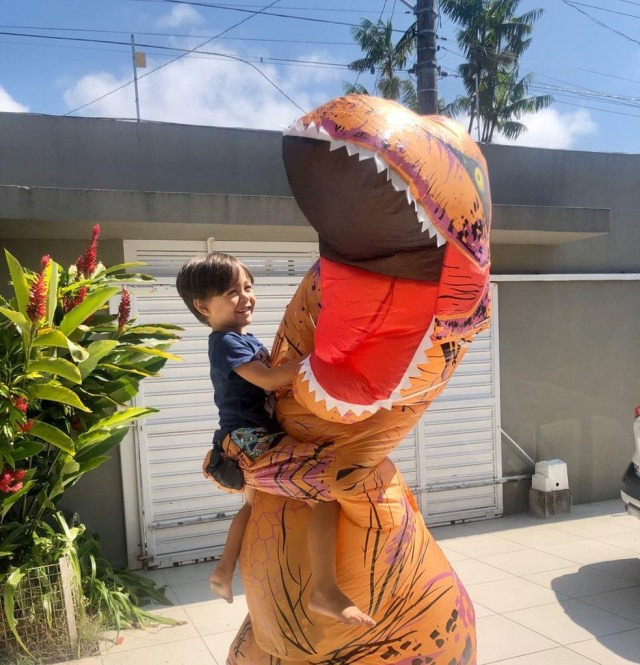 Médico Juan Lambert, fantasiado de dinossauro, abraça o filho Lucca em Caraguatatuba — Foto: Arquivo Pessoal