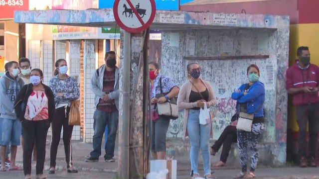 Passageiros à espera de ônibus em parada no DF — Foto: TV Globo/Reprodução