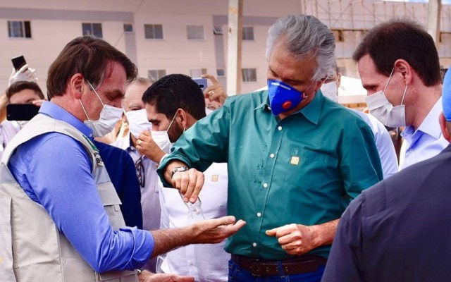 Ronaldo Caiado (DEM) compartilha álcool em gel com presidente Jair Bolsonaro (sem partido) em Águas Lindas de Goiás — Foto: Reprodução/Júnior Guimarães