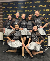 Group of adult students performing at a DANCE1 concert in costume