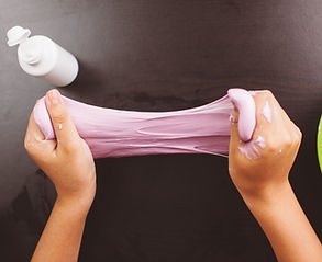 two hands holding and stretching play dough