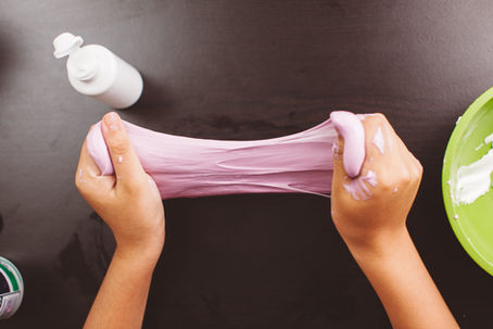 Hands stretching pink slime