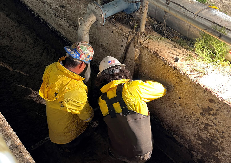 construction workers inside the inlet channel plugging it up. 