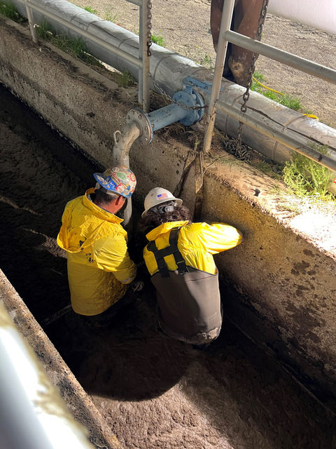 construction workers inside the inlet channel plugging it up. 