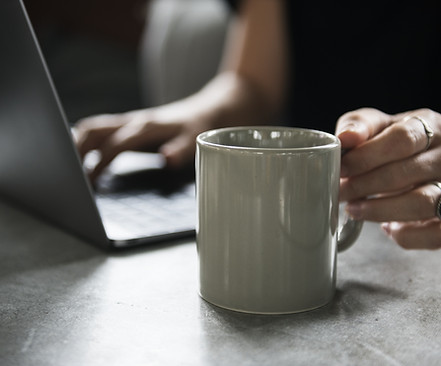 Taza de la bebida y una computadora portátil
