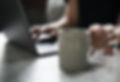 woman typing on laptop with coffee