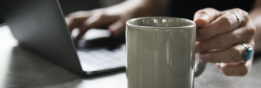 Taza de la bebida y una computadora port