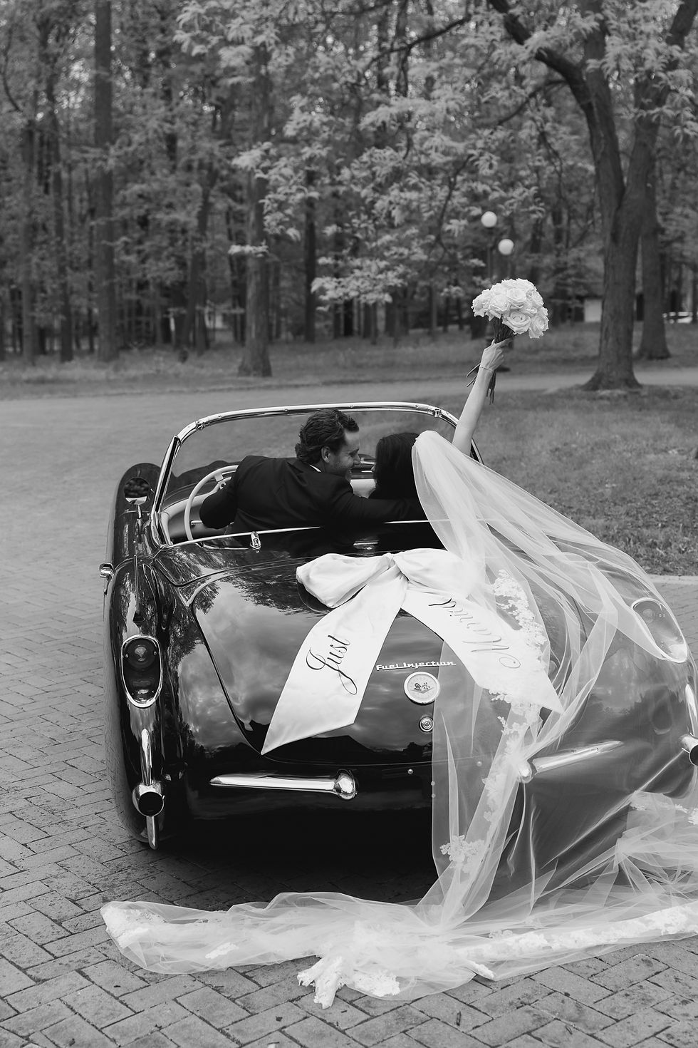 Bride and groom driving away together in vintage 1958 Corvette after emotional Indiana wedding celebration