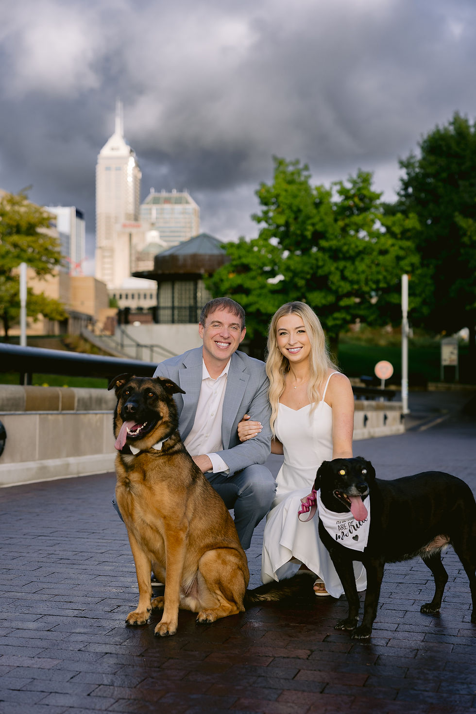 Engagement portraits with dogs on leash in downtown Indianapolis