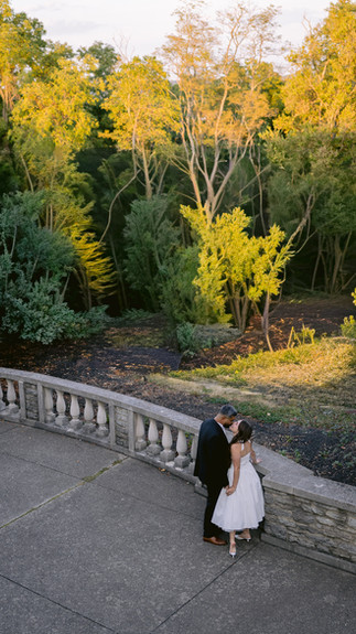 Wide shot of the couple on the steps of the Ault Park pavilion.