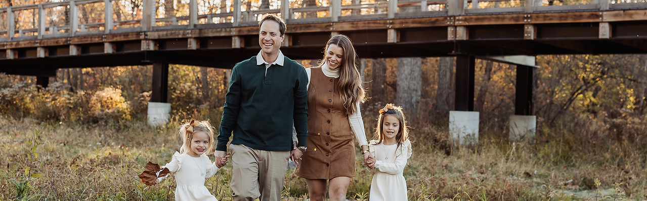 Natural lifestyle family photography session at a Central Indiana park featuring a family walking together during golden hour