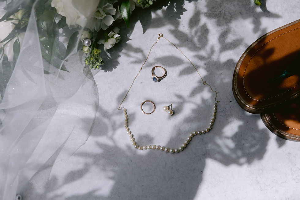 Close-up of wedding invitation suite with delicate floral accents and heirloom jewelry captured in Indianapolis.