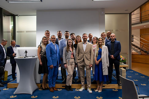Egy üzleti rendezvényen készült fotó, amely mosolygó embereket ábrázol