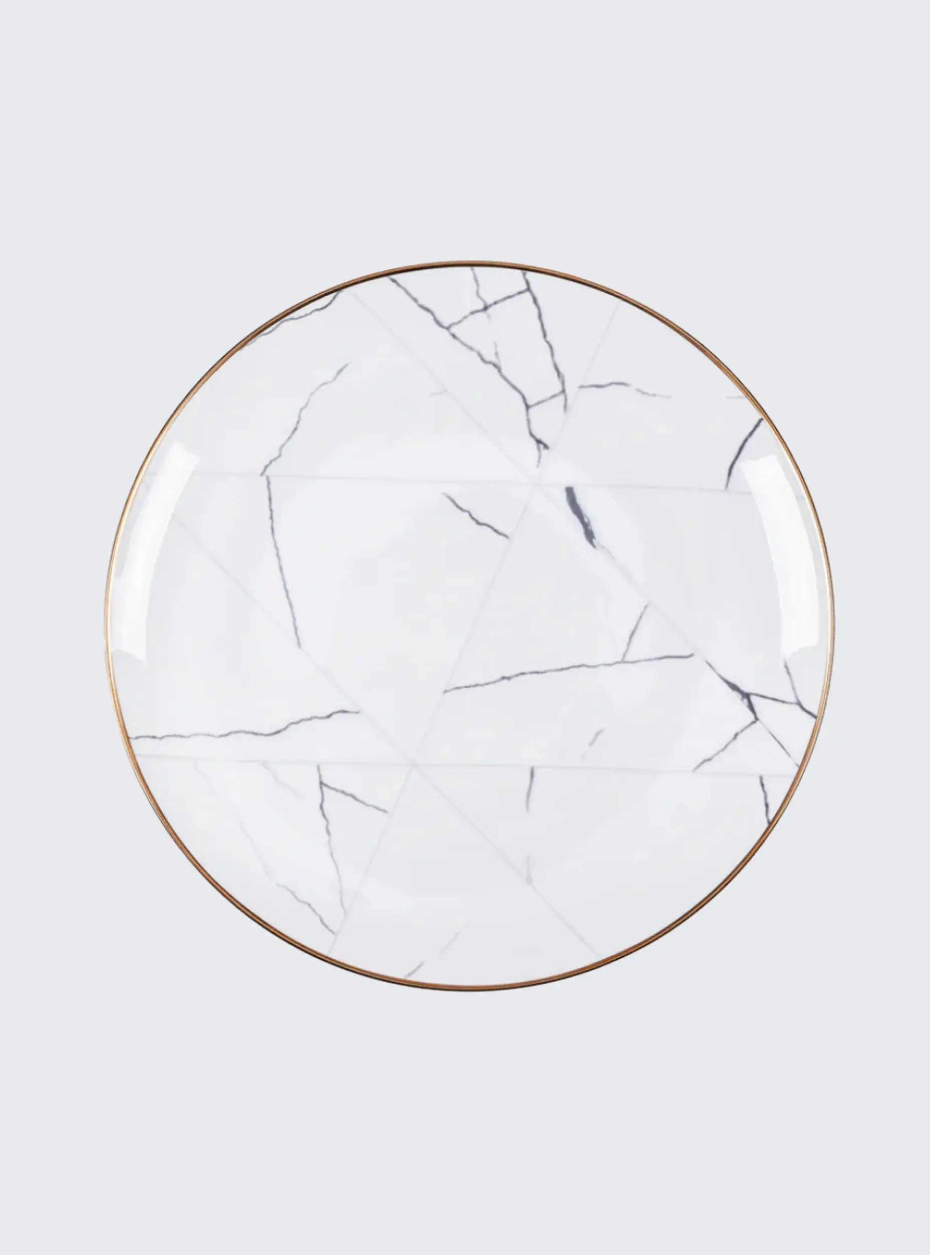 Plato blanco con vetas negras y borde dorado, Plato Trinche Mármol, vista superior.