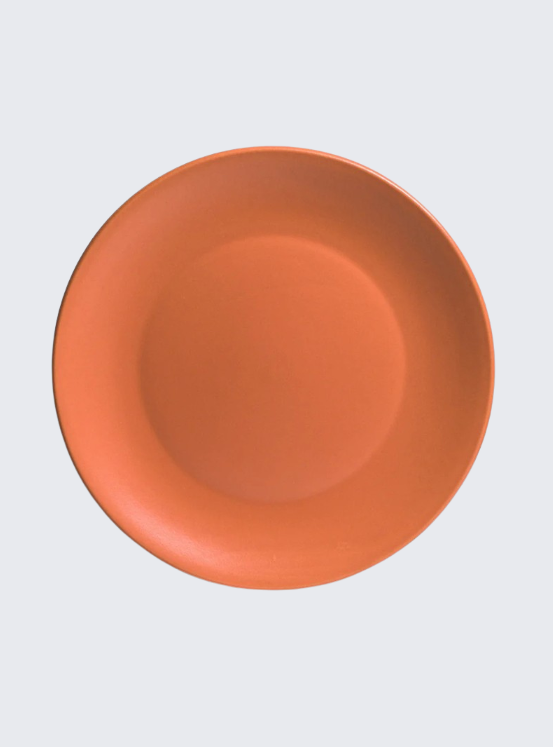 Plato naranja vacío, vista superior, sobre un fondo blanco, sin nada.