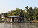 An original raft house visited by small boat on the Sakae Krang river, Uthai Thani